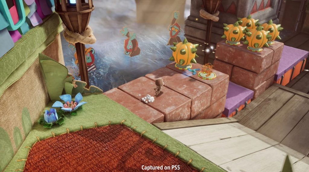 A ps5 screenshot from Sackboy: A Big Adventure, showing a colourful world where Sackboy is throwing a glaive/boomerang ahead of him.