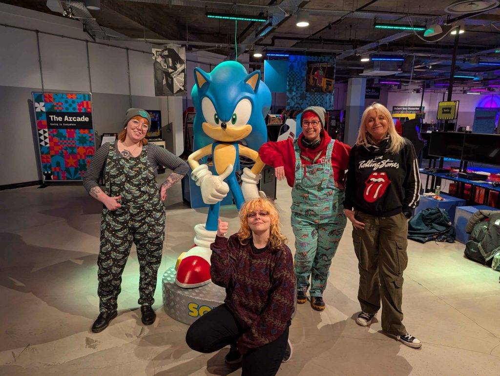 Members of the Safe In Our World team posing for a photo in front of a Sonic statue.