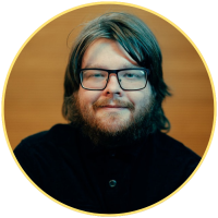 Nathan Dunton wears glasses and is smiling at the camera