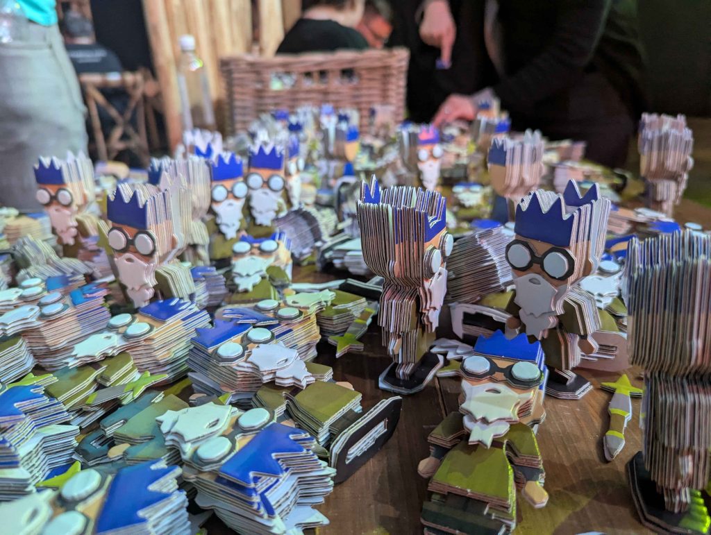 A table of cardboard Wise Old Man figures from RuneScape, built at RuneFest 2025.