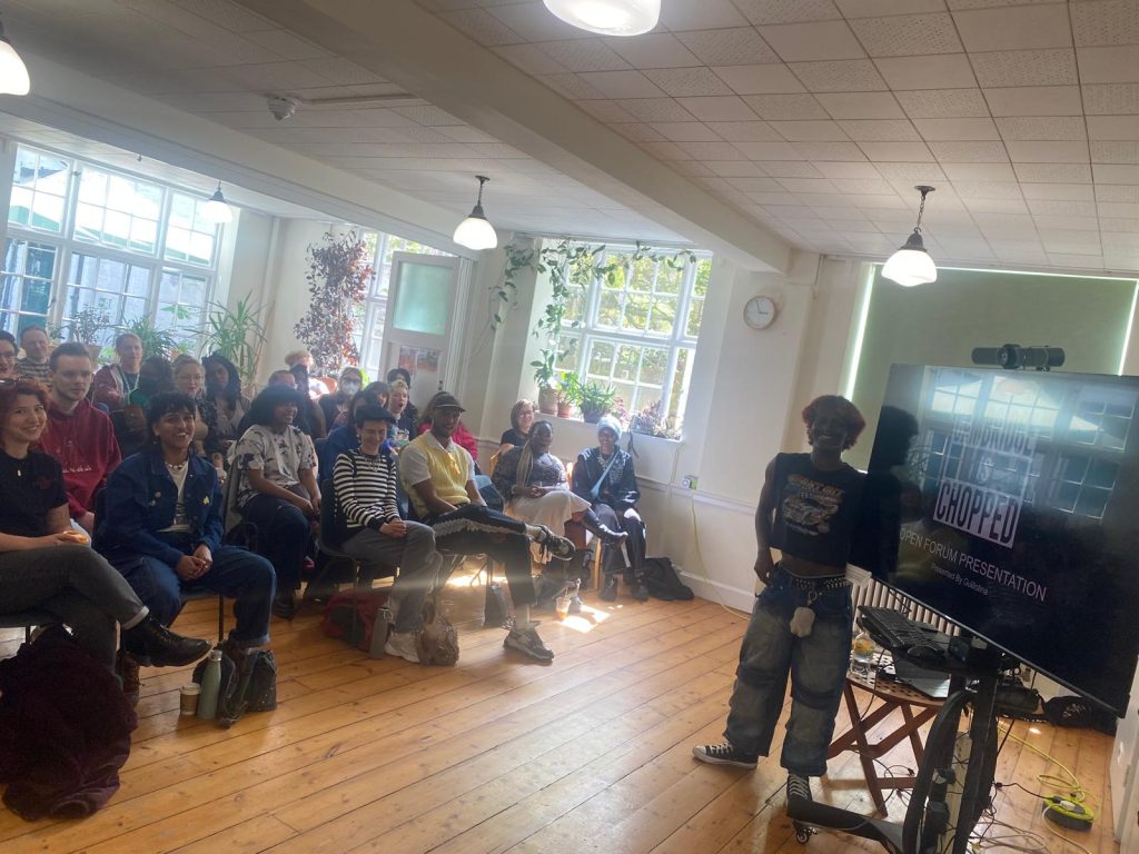 Monroe Botan delivering a presentation of "Cambridge is Chopped" to a room full of people.