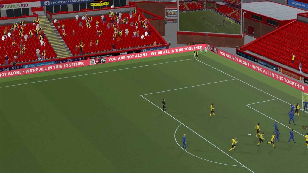 Video game Football Manager features Safe In Our World logo and message "You Are Not Alone - We're All In This Together" on perimeter boards around football pitch.