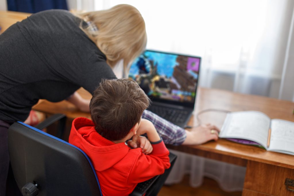 Parent helping child in Minecraft video game.